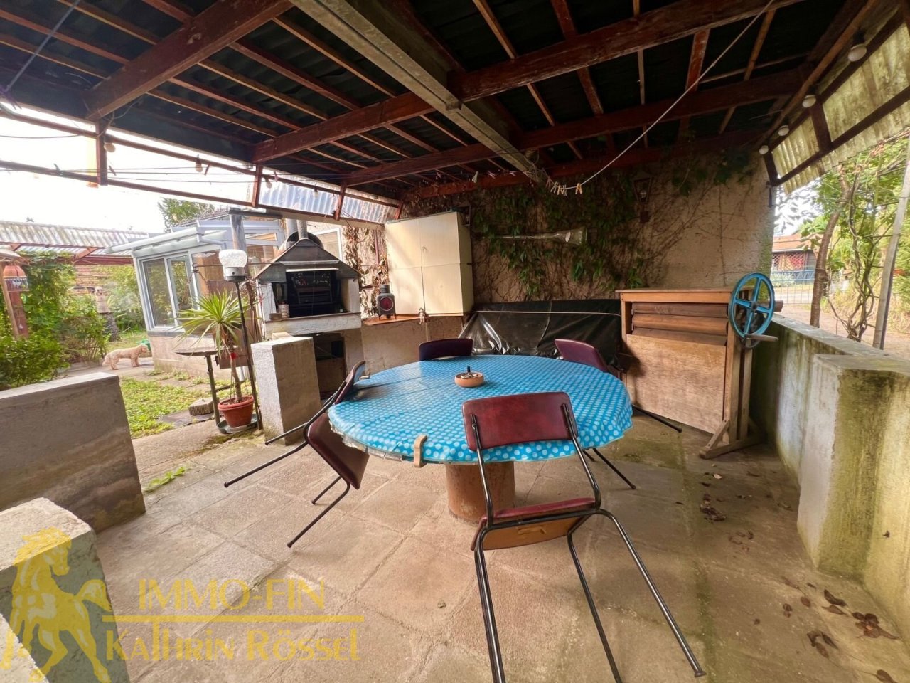 Überdachter Freisitz mit Grill im Hofbereich